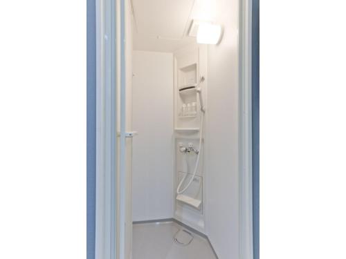 Una ducha a ras de suelo en una habitación blanca con puerta de cristal en Mini Hotel Shinjuku Front - Vacation STAY 89794v, en Tokio