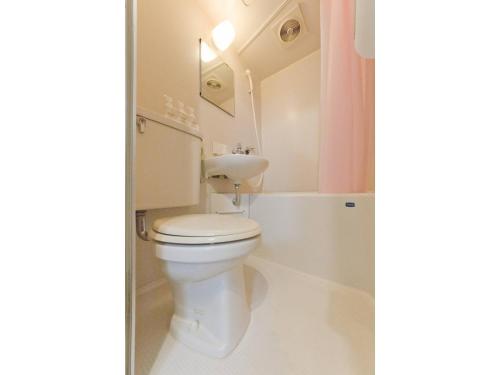 a white bathroom with a toilet and a bath tub at Mini Hotel Shinjuku Front - Vacation STAY 89774v in Tokyo