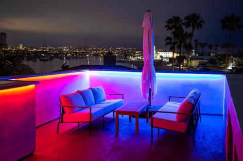 a patio with two chairs and an umbrella at night at The Harbor Lookout in Newport Beach