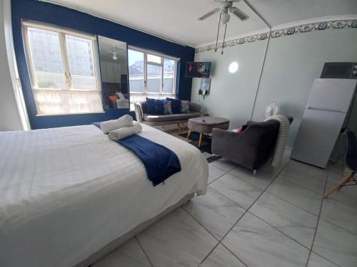 a bedroom with a large bed and a living room at Royal Classico Getaway in Strand Beach in Cape Town