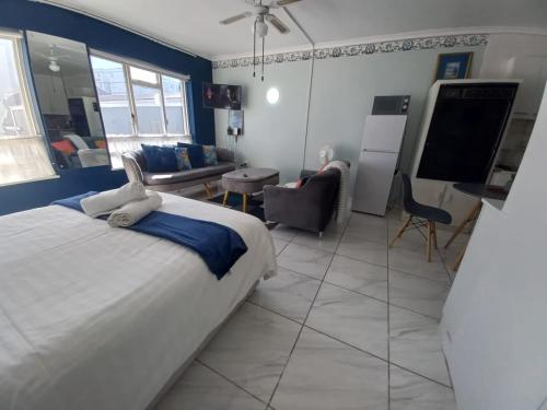 a bedroom with a large bed and a living room at Royal Classico Getaway in Strand Beach in Cape Town