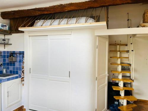 - une cuisine avec un placard blanc et des lits superposés dans l'établissement Studio avec mezzanine, canapé lit., à Grimaud