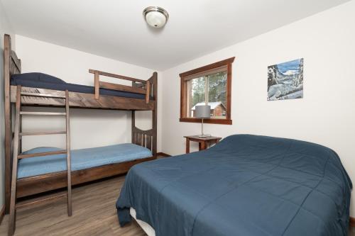 a bedroom with two bunk beds and a blue bed at Aspen in Valemount