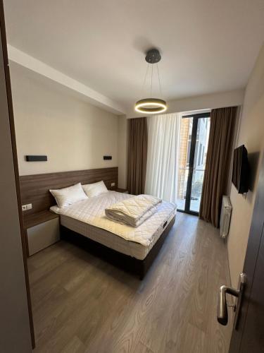 ein Schlafzimmer mit einem Bett und einem großen Fenster in der Unterkunft Crystal Loft Apartment 212 in Bakuriani