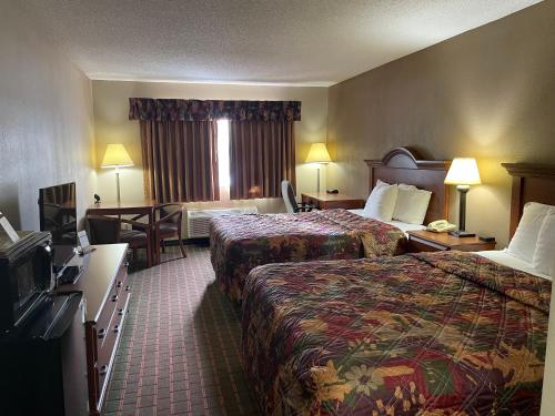 a hotel room with two beds and a television at The Inn in Sault Ste. Marie