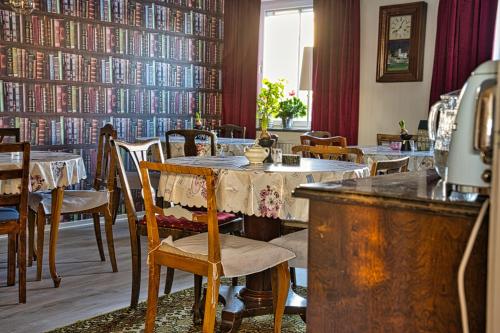a restaurant with tables and chairs in a library at Bed and books på Österlens Gästhärbärge in Glemminge
