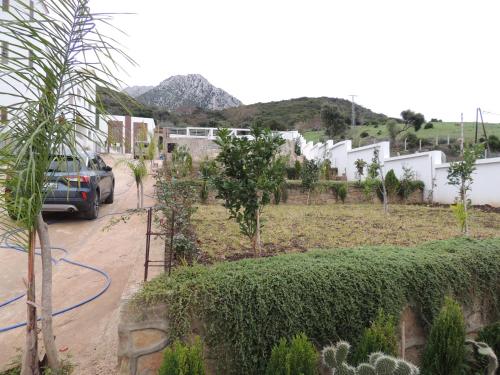 a car parked in front of a yard with trees at Good Life Yellow and Ocean Holiday Apartments in Taoutiet el Bioute
