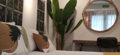 a vase with a plant in a room with a mirror at Le Petit Boutique Hotel in Santander