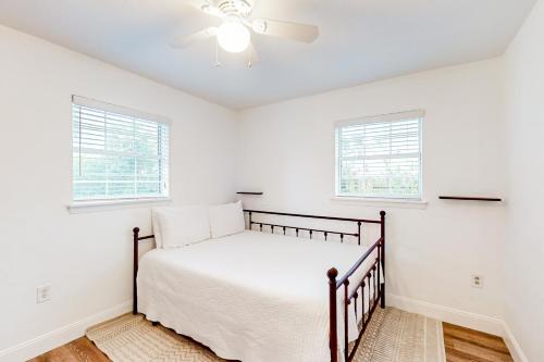 um quarto branco com uma cama e 2 janelas em The Sunset Pearl em Jacksonville Beach