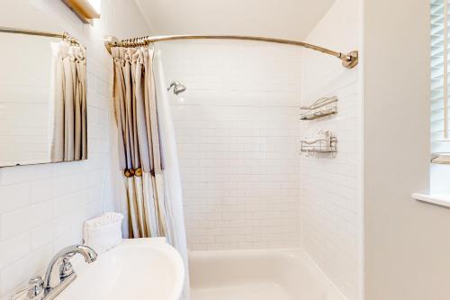 biała łazienka z prysznicem i umywalką w obiekcie The Sunset Pearl w mieście Jacksonville Beach