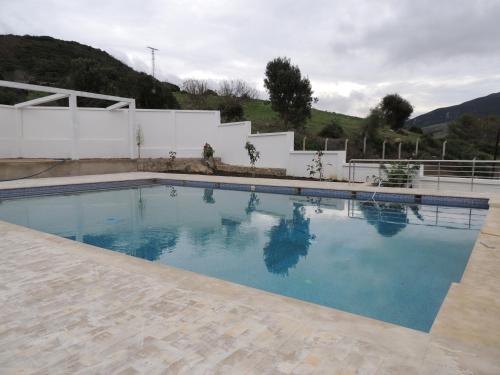 a swimming pool with blue water in front of a house at Good Life Yellow and Ocean Holiday Apartments in Taoutiet el Bioute