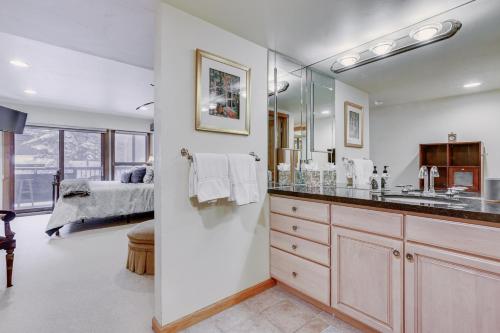 a bathroom with a sink and a mirror and a bed at Condo Near Golf Club about 2 Mi to Vail Ski Resort! in Vail