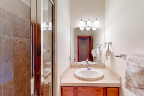 a white bathroom with a sink and a shower at Saddle Ridge Ranch in Granby