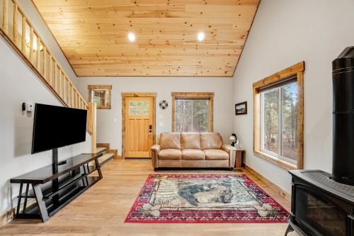 a living room with a couch and a flat screen tv at Experience Montana - Luxury Cabins #1, 6, 7, 8 & 9 in Bigfork