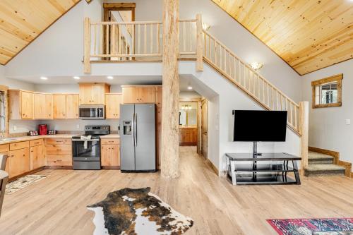 a kitchen with a refrigerator and a tv in a room at Experience Montana - Luxury Cabins #1, 6, 7, 8 & 9 in Bigfork