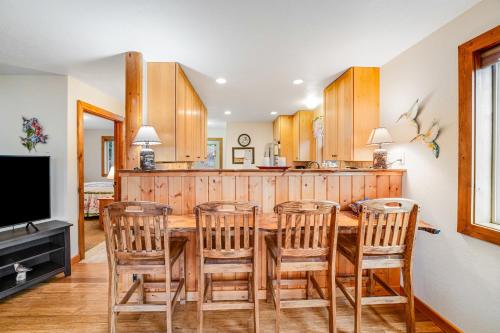 a kitchen with a wooden table and chairs and a television at Experience Montana - Luxury Cabins #1, 6, 7, 8 & 9 in Bigfork
