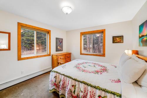 a bedroom with a bed and two windows at Experience Montana - Luxury Cabins #1, 6, 7, 8 & 9 in Bigfork