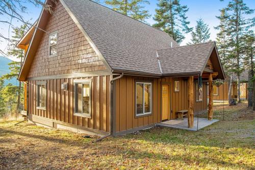 a small wooden house with a gambrel roof at Experience Montana - Luxury Cabins #1, 6, 7, 8 & 9 in Bigfork