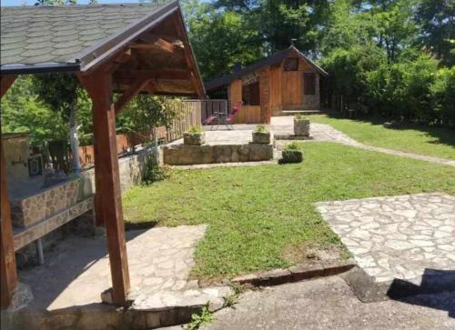 a backyard with a wooden pavilion and a house at Popović na Drini in Bajina Bašta