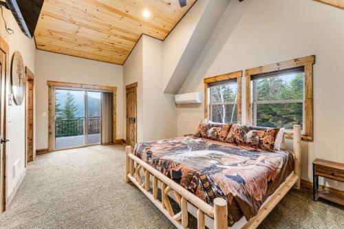 a bedroom with a large bed in a room with windows at Experience Montana - Luxury Cabins #1, 6, 7, 8 & 9 in Bigfork