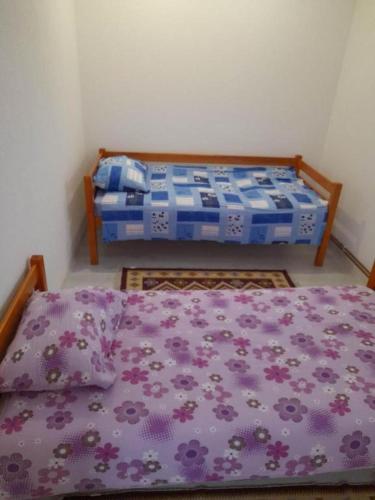 two beds in a room with purple sheets at Neli Carica in Visoko