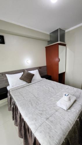 Un dormitorio con una cama grande con una toalla. en HOSTAL EL REFLEJANTE, en Tacna