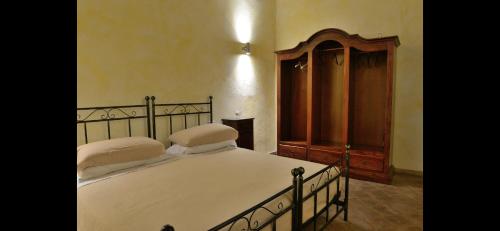 a bedroom with a large bed and a wooden cabinet at Villa Pepoli in Monteleone Sabino