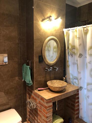 y baño con aseo de piedra y espejo. en Casa de Mar Azul en Balneario Mar Azul
