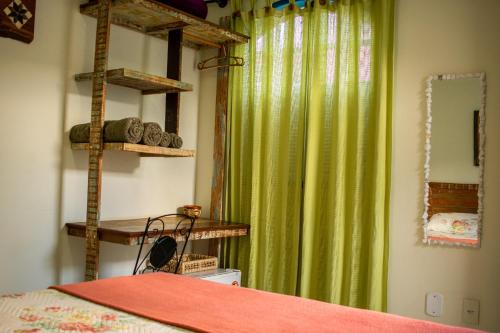 um quarto com uma cama e uma cortina verde em Acapela Hospedagem em Ouro Preto