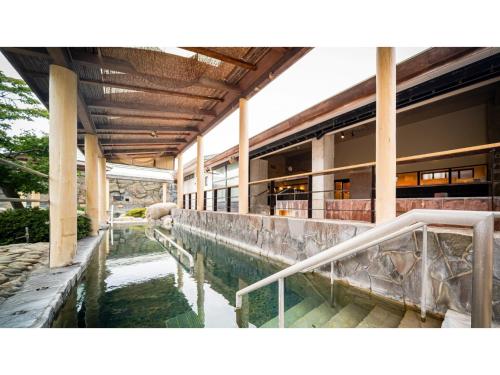 - un bâtiment avec une piscine d'eau en face dans l'établissement Kutsurogi no Yado Juraku - Vacation STAY 03511v, à Tobe