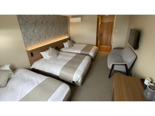 een hotelkamer met 2 bedden, een bureau en een stoel bij Kutsurogi no Yado Juraku - Vacation STAY 03512v in Tobe