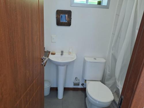 a bathroom with a toilet and a sink at La Estacion Colonia in Colonia del Sacramento
