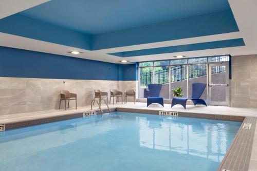 - une piscine dans un hôtel avec des murs et des chaises bleus dans l'établissement Hampton Inn Midland, On, à Midland