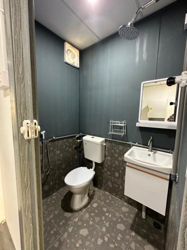 a bathroom with a toilet and a sink and a mirror at Homestay Denai Harummanis S4 in Simpang Empat