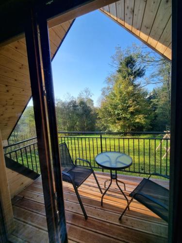 a view from the porch of a cabin with a table and chairs at Chatka Przy Miedzy in Jabłonka