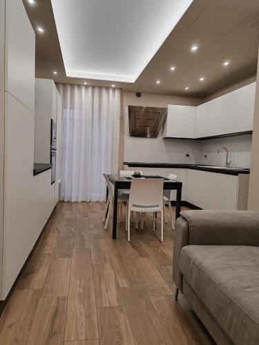 a kitchen and dining room with a table and a couch at MÌLÙ BED and HOME in Bitonto
