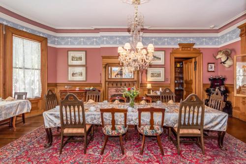 a dining room with a table and chairs and a chandelier at Chateau Tivoli Bed and Breakfast in San Francisco