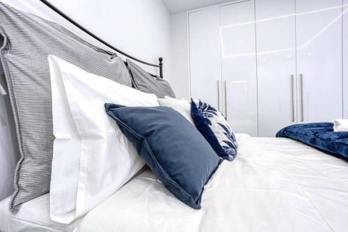 a bed with blue and white pillows on it at Luminous Luxury House in Pýli