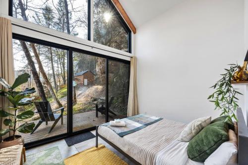 a room with a bed and a large window at Tiny Cabin in RRG - The Naturalist in Rogers