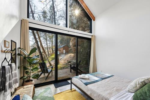 a bedroom with a bed and a large window at Tiny Cabin in RRG - The Naturalist in Rogers