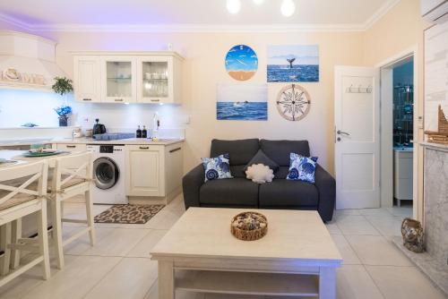 a living room with a couch and a kitchen at The Nautical Nook in Marsaxlokk