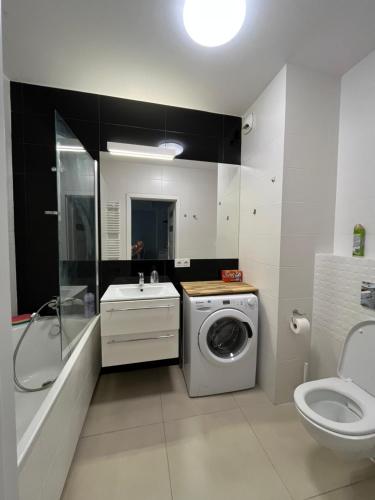 a bathroom with a washing machine and a sink at cybernetyki2 street INN near airport in Warsaw