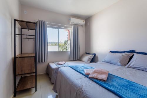 1 dormitorio con 2 camas y ventana en Curta Praia de Armação - Casa Orquídea, en Penha