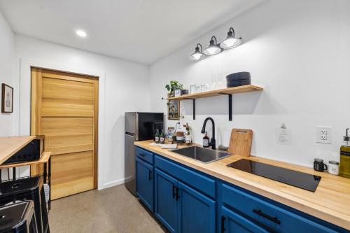 a kitchen with blue cabinets and a sink at Tiny Cabin in RRG - The Naturalist in Rogers