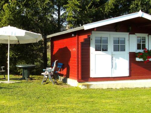 a red shed with a white door and a table at Holiday home in Olsdorf in Bettingen