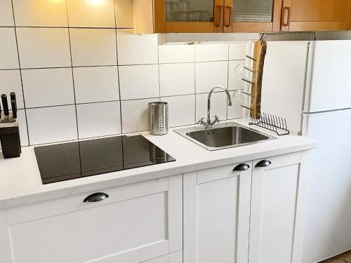 a white kitchen with a sink and a refrigerator at Holiday home HOLMSJÖ III in Holmsjö