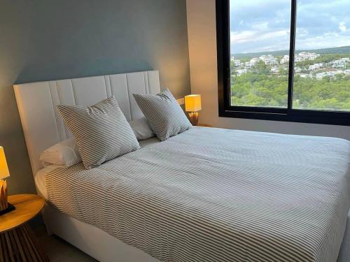 ein Schlafzimmer mit einem großen Bett mit einem großen Fenster in der Unterkunft Fantastic apartment in Las Colinas Golf (4 people) in Orihuela