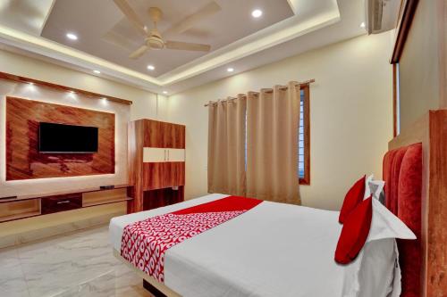 a bedroom with a bed and a flat screen tv at OYO Flagship OXY QUEEN PALACE in Jamshedpur