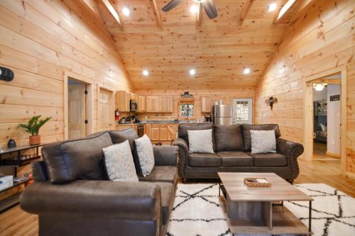 a living room with two couches and a table at Tsaliwood Cabin in Sevierville