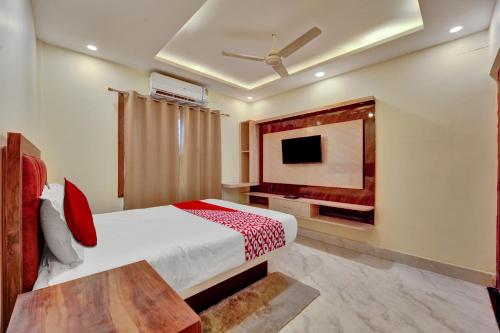 1 dormitorio con 1 cama y TV en la pared en OYO Flagship OXY QUEEN PALACE, en Jamshedpur